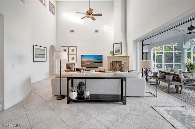 tiled living room featuring a towering ceiling and ceiling fan