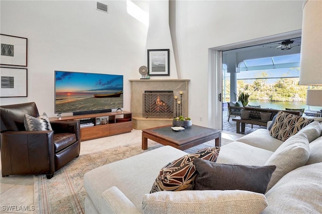 living room with a towering ceiling and a high end fireplace