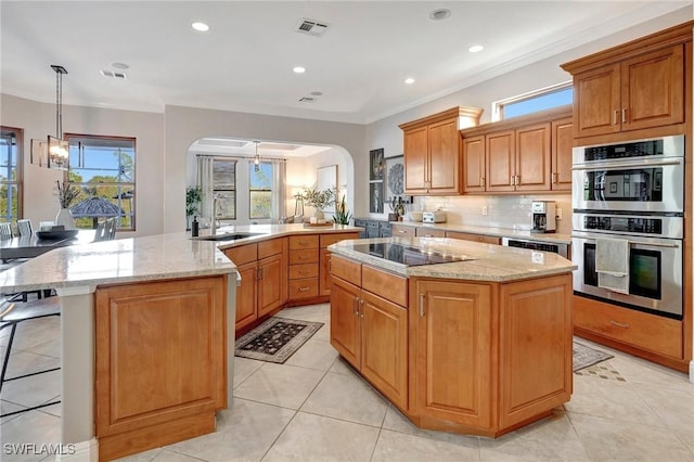 kitchen featuring pendant lighting, double oven, plenty of natural light, black electric stovetop, and a kitchen island