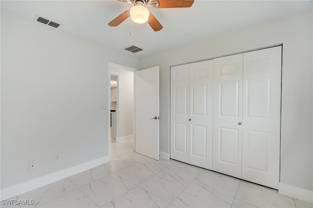 unfurnished bedroom with marble finish floor, a closet, visible vents, and baseboards