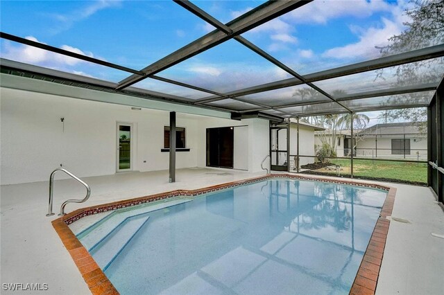 view of pool featuring glass enclosure and a patio area