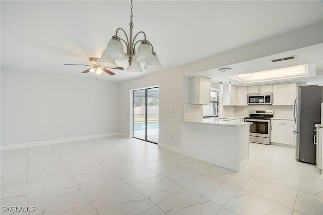 kitchen featuring stainless steel appliances, visible vents, light countertops, white cabinetry, and a peninsula