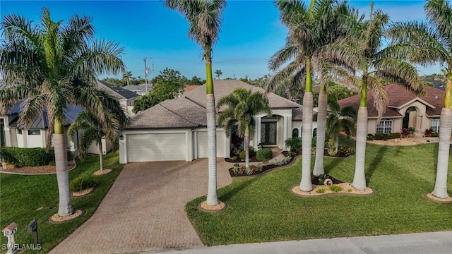 view of front of home with a front yard and a garage