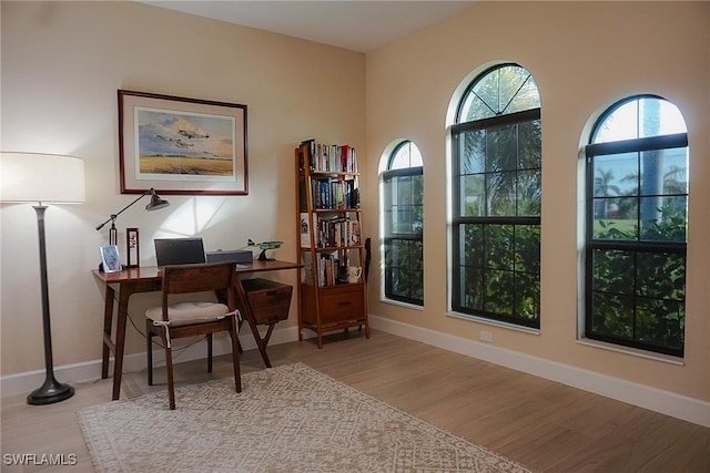 home office with light hardwood / wood-style floors