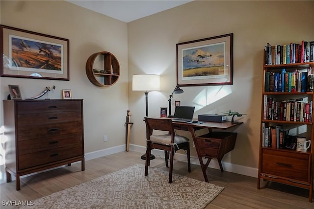 home office with light hardwood / wood-style flooring