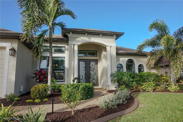 doorway to property featuring a lawn and french doors