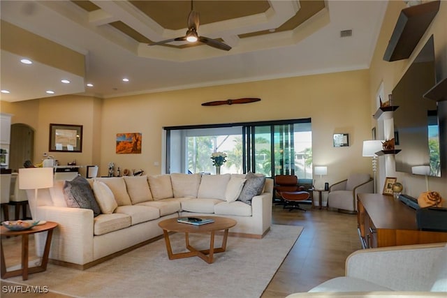 living room featuring ceiling fan, ornamental molding, and a high ceiling