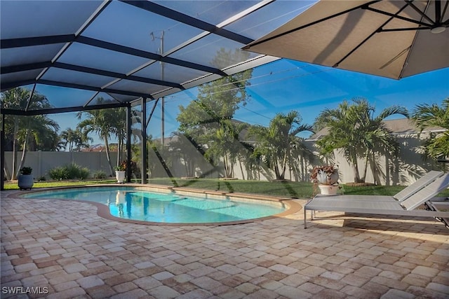 view of pool with glass enclosure and a patio area