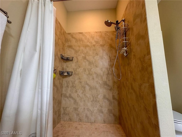 bathroom featuring toilet and curtained shower