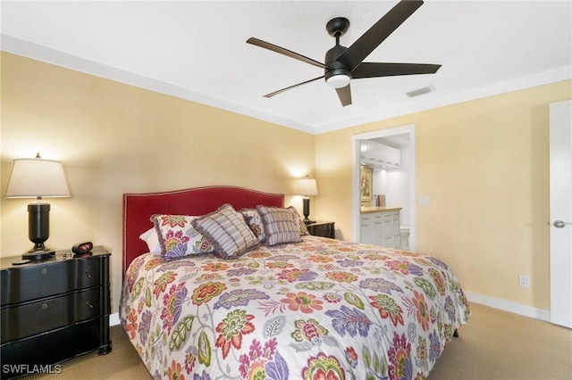 carpeted bedroom featuring ensuite bathroom, crown molding, and ceiling fan