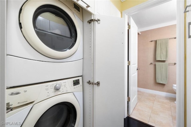 laundry room featuring light tile patterned flooring and stacked washer and dryer