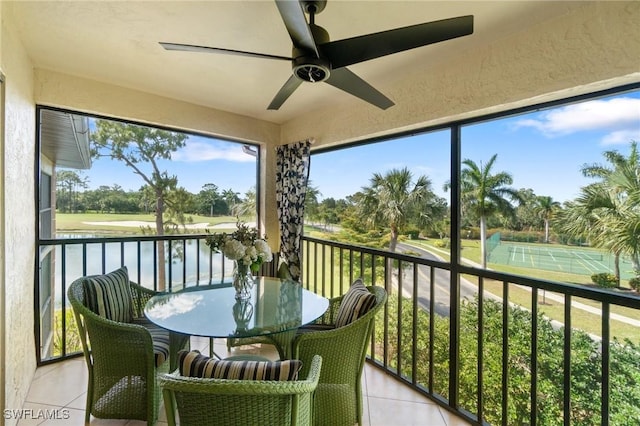 sunroom / solarium with a water view and ceiling fan