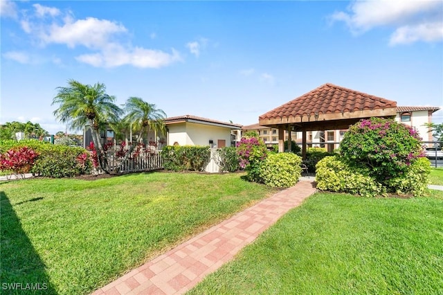 view of front of property featuring a front yard and a gazebo