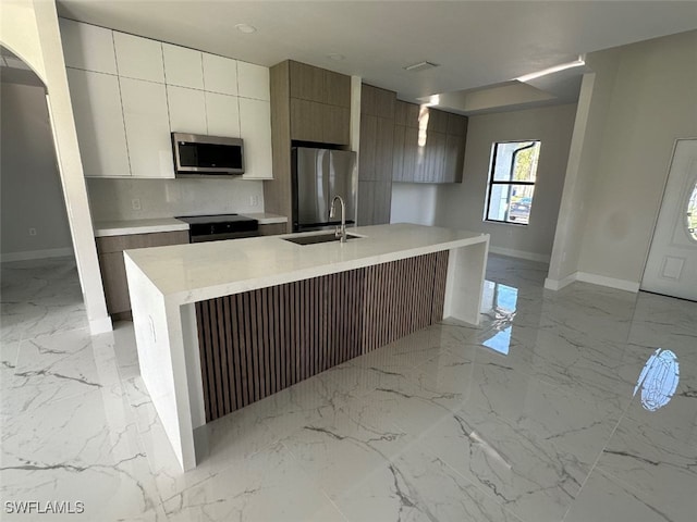 kitchen featuring sink, a kitchen island with sink, and appliances with stainless steel finishes