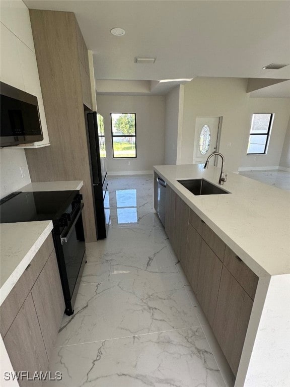 kitchen featuring black appliances, a large island, and sink