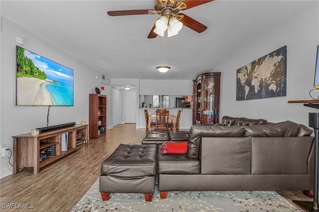 living room with light hardwood / wood-style floors and ceiling fan