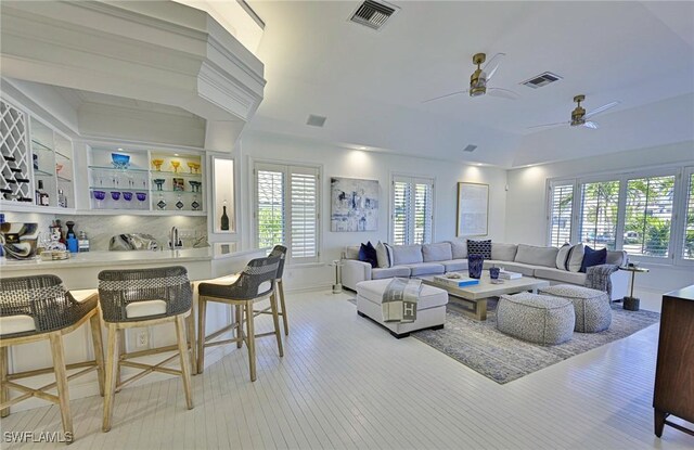 living room with ceiling fan and built in shelves