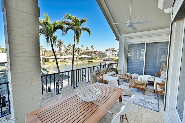 balcony with ceiling fan, outdoor lounge area, and a water view