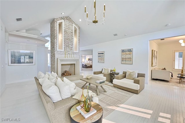 living room with a large fireplace, ornamental molding, lofted ceiling, and an inviting chandelier