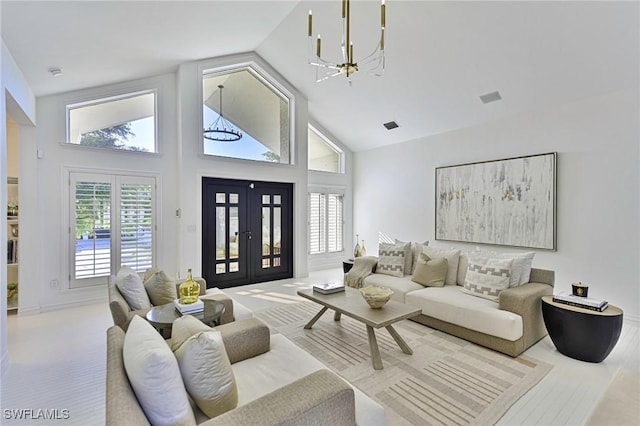 living room featuring an inviting chandelier, light colored carpet, french doors, and high vaulted ceiling