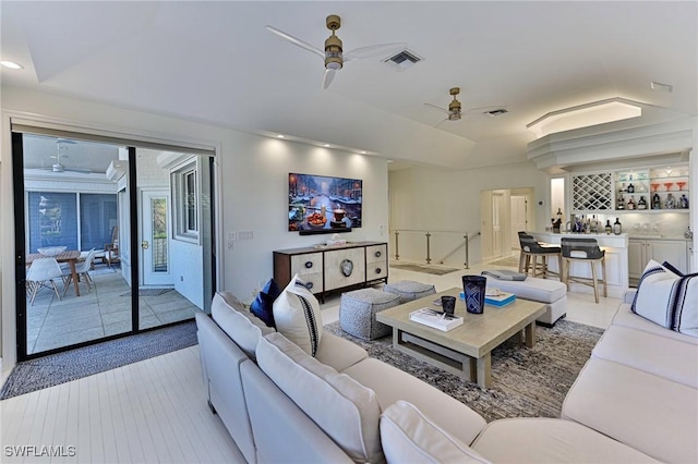 living room featuring bar and ceiling fan