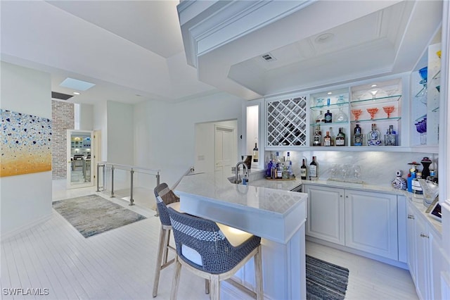 bar featuring decorative backsplash and white cabinetry