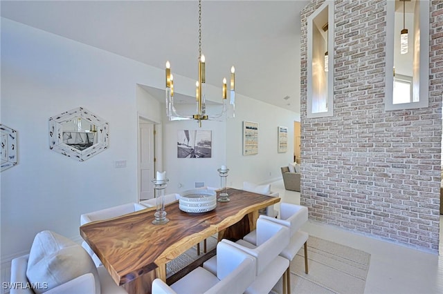 dining room featuring a notable chandelier, brick wall, and concrete flooring