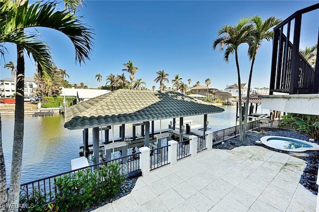 dock area with a water view and an in ground hot tub