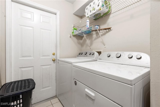 laundry room featuring washer and clothes dryer and light tile patterned floors