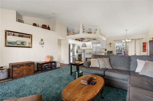 living room featuring hardwood / wood-style flooring, high vaulted ceiling, and a notable chandelier