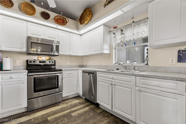 kitchen with white cabinets, sink, decorative light fixtures, dark hardwood / wood-style flooring, and stainless steel appliances