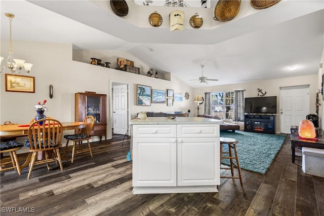 kitchen with dark wood-type flooring, white cabinets, decorative light fixtures, and ceiling fan with notable chandelier