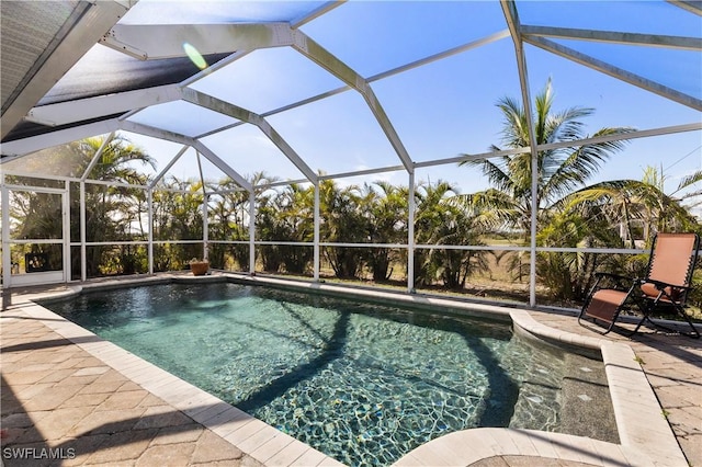 view of swimming pool featuring a patio and a lanai