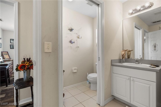 bathroom with tile patterned flooring, vanity, and toilet