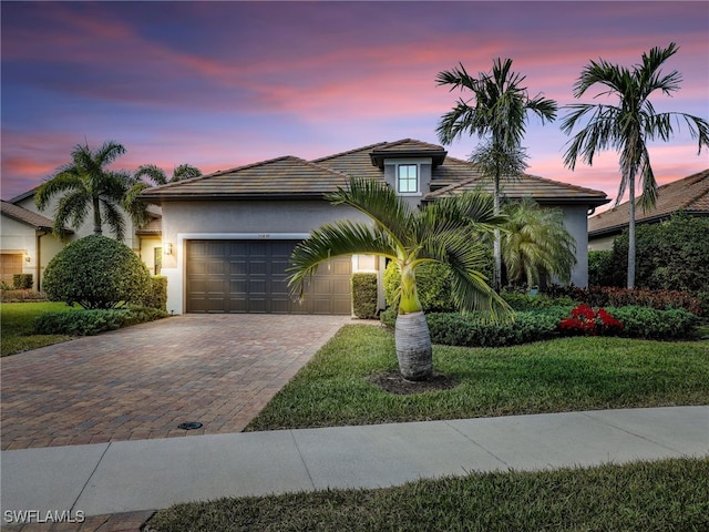 view of front of home with a yard and a garage