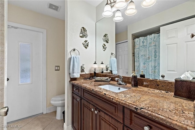 bathroom with tile patterned flooring, vanity, toilet, and a notable chandelier