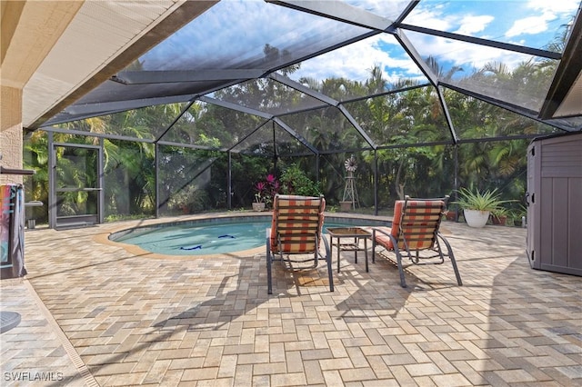 view of pool with glass enclosure and a patio area