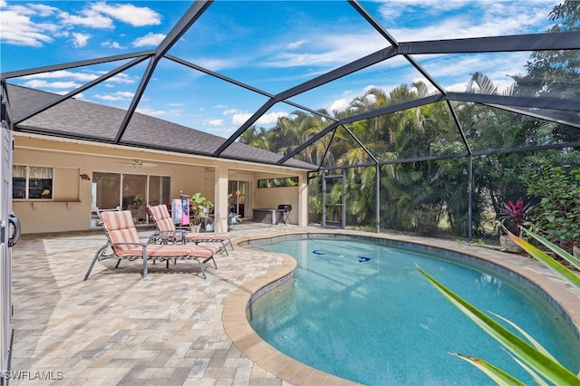 view of swimming pool with a lanai, ceiling fan, and a patio