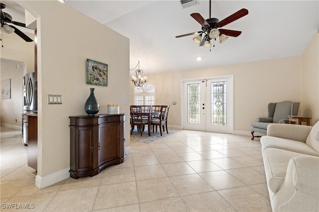 tiled living room featuring french doors and ceiling fan with notable chandelier