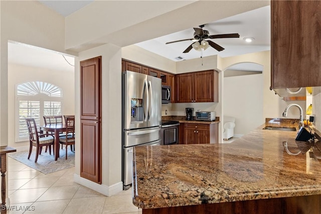 kitchen with sink, kitchen peninsula, stainless steel appliances, and stone counters