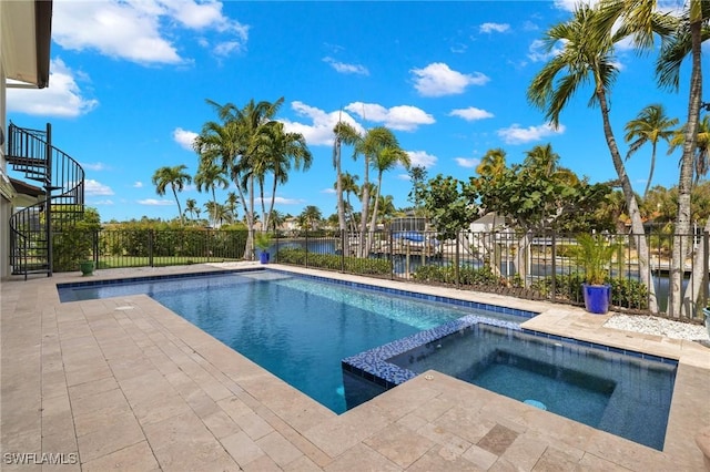 view of swimming pool featuring an in ground hot tub and a water view