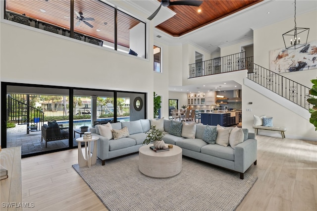 living room featuring a high ceiling, ceiling fan with notable chandelier, light hardwood / wood-style flooring, and wood ceiling