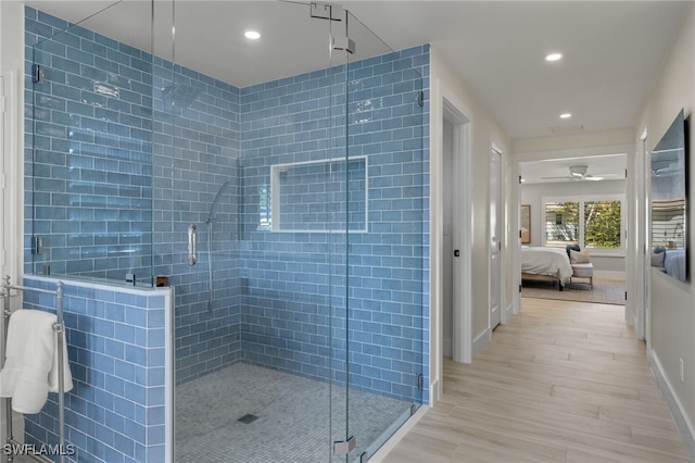 bathroom with an enclosed shower and hardwood / wood-style flooring