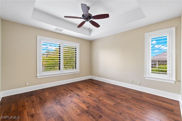 unfurnished room featuring dark hardwood / wood-style floors and a raised ceiling