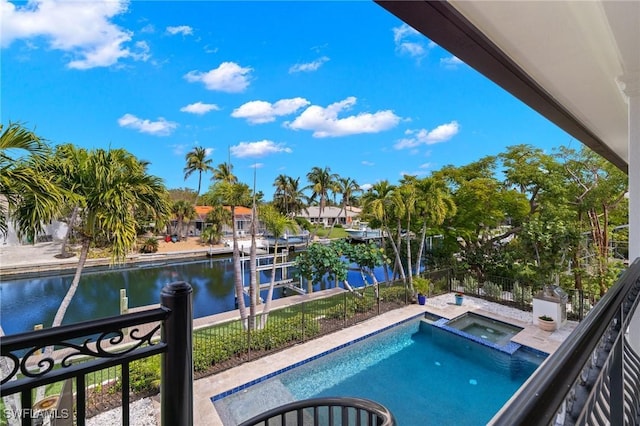 view of swimming pool with an in ground hot tub, a water view, and a boat dock