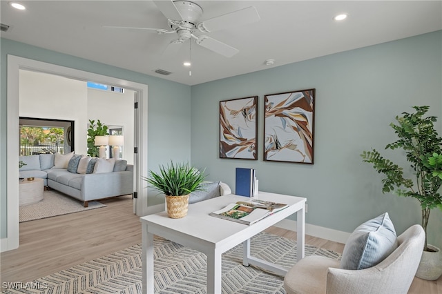 home office with ceiling fan and light hardwood / wood-style floors