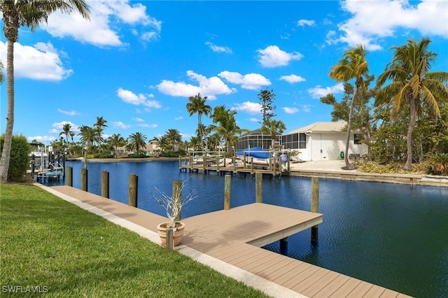 view of dock featuring a lawn and a water view