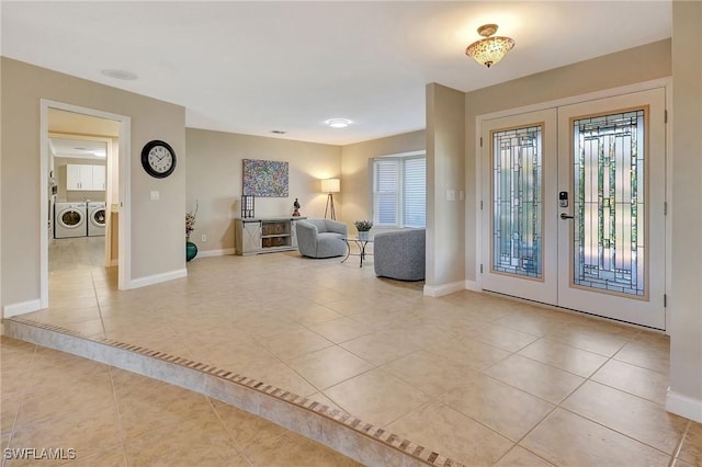 entryway with separate washer and dryer, french doors, and light tile patterned floors