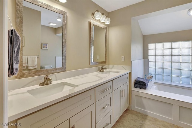 bathroom with tile patterned flooring, vanity, toilet, and a bathing tub