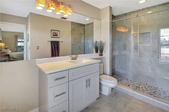 bathroom featuring tile patterned flooring, vanity, toilet, and a shower with door